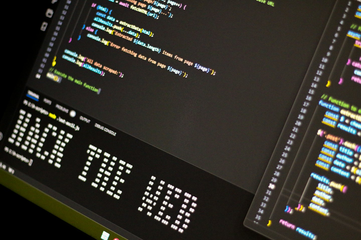 Computer screen displays colorful programming code and ASCII art.